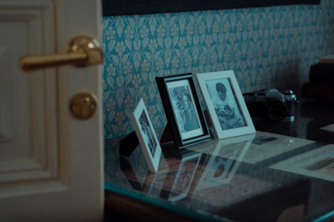 Elegant display of vintage photo frames and classic camera on glass table.